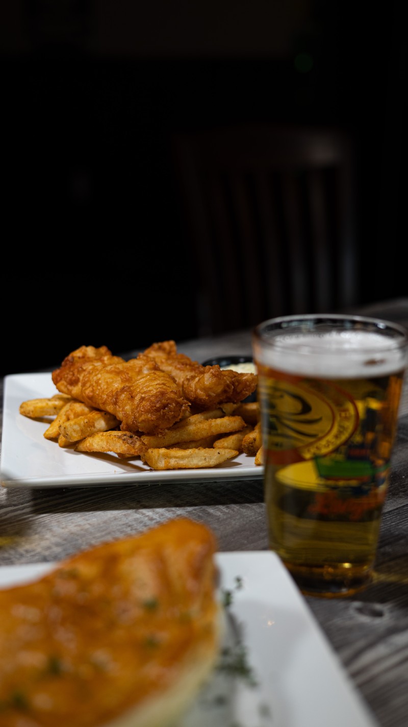 A plate of fish and chips and a glass of beer.
