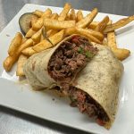 A beef burrito with french fries on a plate.
